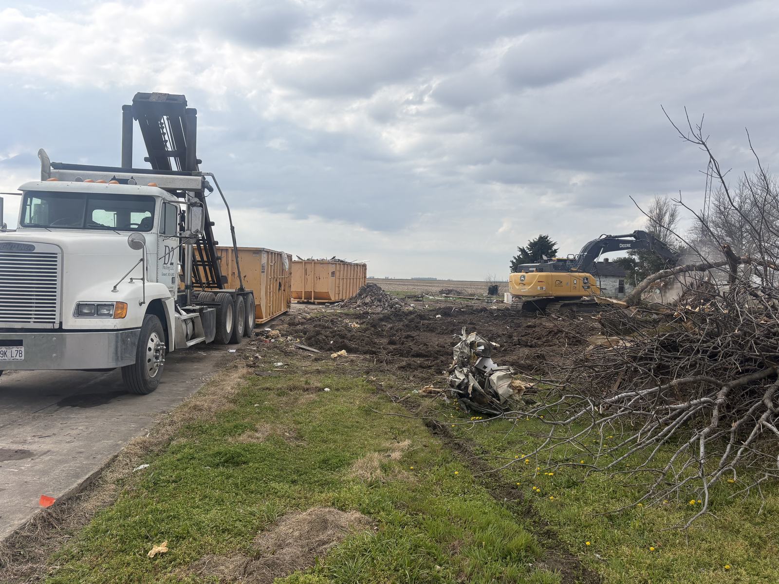 D2 Dumps roll-off truck delivering dumpsters at a cleanout job near Kennett, Missouri
